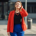 Mladá plus size žena stojaca vonku v modernom outfite s mestským pozadím a prirodzeným svetlom