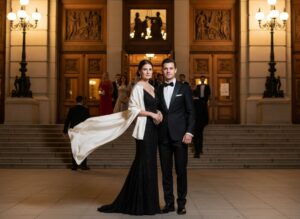 Elegantný pár pred symfonickou koncertnou halou večer v spoločenskej elegancii.